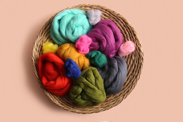 Wicker basket with different wool for felting on color background © Pixel-Shot