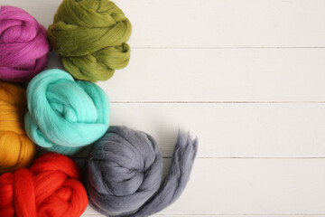 Set of colorful wool for felting on light wooden background