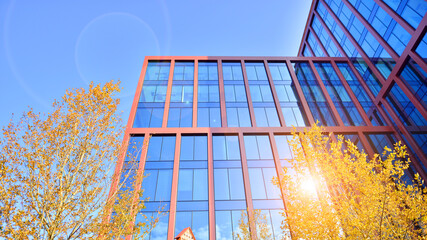 Sustainable glass office building with trees for reducing carbon dioxide. Eco-friendly building in...