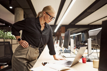 A professional woman is efficiently working at a modern office desk, showcasing her skills