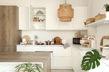 Interior of modern kitchen with counters, cupboards and utensils