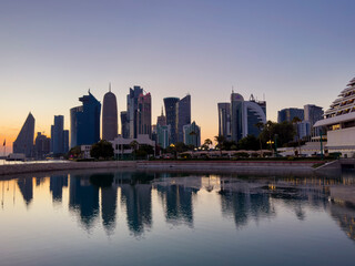 Fototapeta premium A beautiful view during sunset of the Doha Towers, the sea and boats, Doha, Qatar