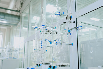 Several pieces of intricate laboratory glassware with connected tubes and flasks are set up in a...