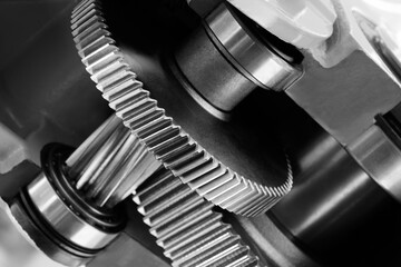 A close up of a gear with a black and silver color scheme. The gear is surrounded by a black and...