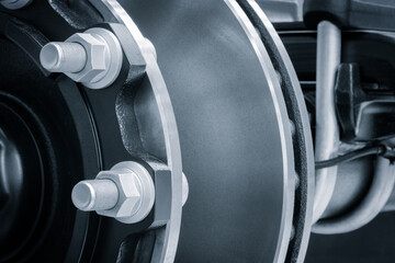 A close up of a wheel with a lot of bolts and nuts. The wheel is black and silver, industrial...