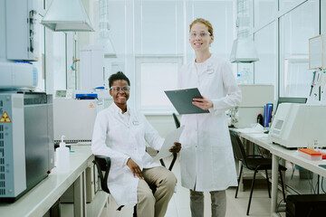 Scientists conducting groundbreaking research in high-tech laboratory, wearing lab coats and safety glasses while analyzing data and samples with advanced equipment