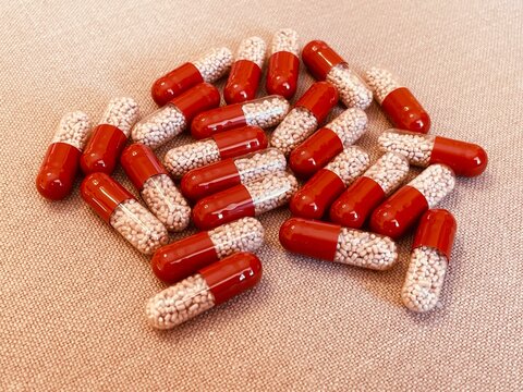 Red and transparent medication capsules containing pancreatic enzyme