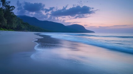 Fototapeta premium Tranquil beach at twilight with soft waves lapping the shore