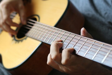 lose-up shots capture hands skillfully playing chords and melodies along the neck of an acoustic guitar