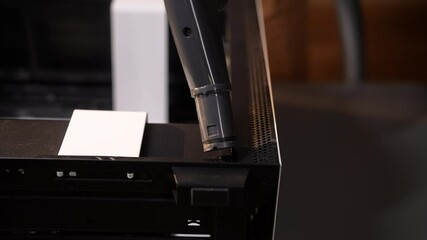 Closeup of unrecognizable computer technician cleaning inside of desktop computer using small vacuum cleaner, ensuring optimal performance. Process of importance of computer maintenance, slow motion.
