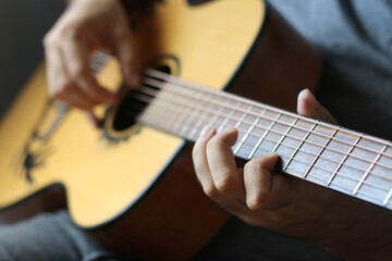 lose-up shots capture hands skillfully playing chords and melodies along the neck of an acoustic...