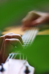 Through the cut-outs of a monstera leaf, hands can be seen playing chords and melodies