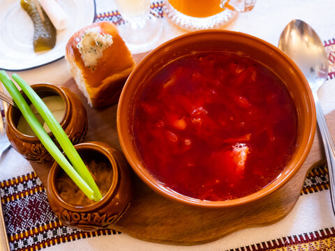 Borscht, beetroot hot soup and garlic bread pampushka on the table in a cafe