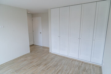 closet de habitacion moderna en departamento con piso de madera