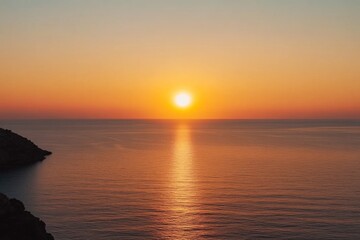 Fototapeta premium Stunning sunset photograph capturing an orange sky over the sea, with the sun gracefully setting on the horizon, showcasing a beautiful seascape view from above.