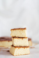 A close-up of three stacked pieces of Bica Blanca de Laza, a traditional Galician sponge cake with a fluffy texture and a cinnamon crust on top.