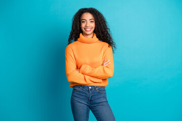 Portrait of nice young girl folded arms empty space wear orange sweater isolated on turquoise color...