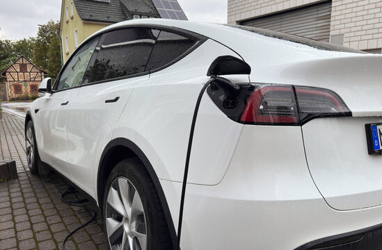 Karben, Germany- 25. Septmeber 2024. Tesla EV electric vehicle charging during rain