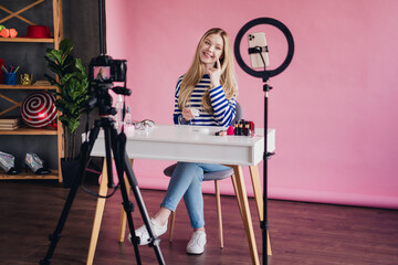 Photo of charming cute girl vlogger showing cosmetics online stream video vlog in studio indoors