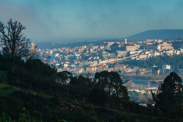 daytime panoramic view of Coimbra, Portugal, showcasing the city's layered architecture along the hillside