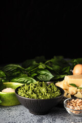 Homemade Pesto Sauce with Pine Nuts and Basil: Ingredients on Black Background