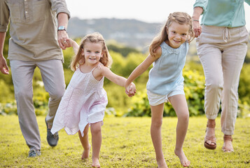 Fototapeta premium Parents, holding hands and portrait of girl children with smile, outdoor fun and weekend morning bonding together. Mom, dad and kids running in garden for happy family, relax and love in nature.