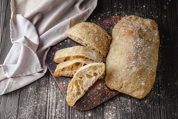 Ciabatta Italian bread with Olive Oil: Fresh, Rustic, Homemade, and Delicious on a Wooden Table