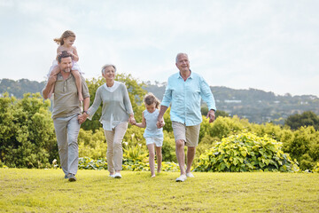 Family, generations and holding hands in park with kids, smile and outdoor fun on weekend morning together. Grandparents, dad and girl children in garden for happy bonding, relax and love in nature