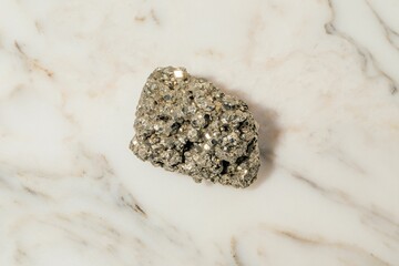 pyrite nugget rock on white marble