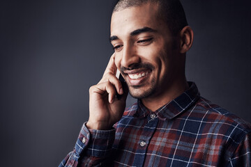 Man, happy or phone call in studio for contact, good news or feedback for creative small business. Designer, entrepreneur or smile with tech for networking with conversation on black background space