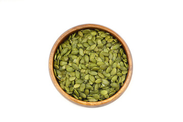 Pumpkin seeds in a wooden bowl on a white background