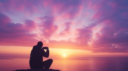 Fototapeta premium Silhouette of a Man Capturing the Breathtaking Sunset Over the Ocean with a Camera