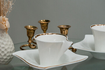 Elegant Tea Set Displayed with Golden Candle Holders and Floral Arrangement
