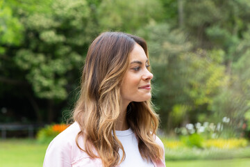 Naklejka premium Smiling woman enjoying peaceful moment in lush green park setting