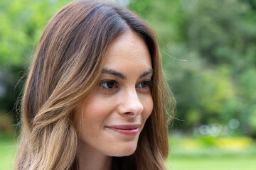 Smiling woman enjoying peaceful moment outdoors in lush green garden