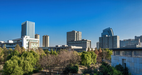 Obraz premium Blue Sky Over Urban Park and Corporate Buildings