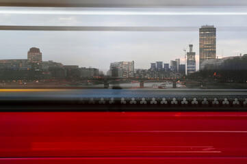 View of London bridge through passing red bus