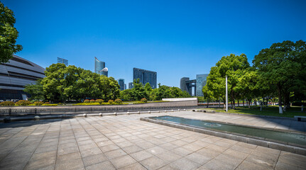 Vibrant Urban Park with Skyscrapers Under Clear Blue Sky