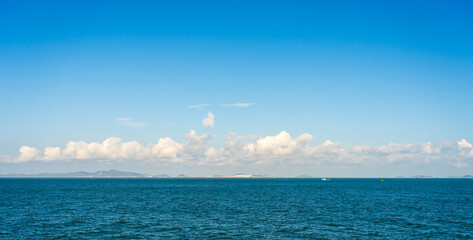 Obraz premium Serene Ocean View Under a Clear Blue Sky with Diffused Clouds