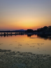 Serene Sunset Over Tranquil Lake with Reflections and Silhouetted Figures