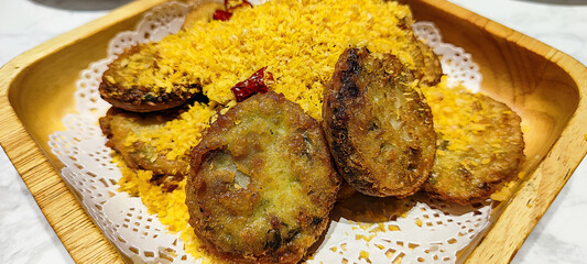 Savory Fried Snacks Served with Crispy Flakes on a Wooden Plate