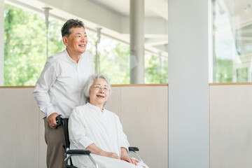 Fototapeta premium 老人ホーム・介護施設にいる高齢者・シニア夫婦・車椅子の女性 