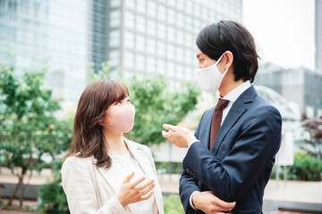 マスク姿のビジネスマン、ビジネスウーマン（話す）
