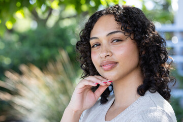 Woman in natural sunlight, smiling and appreciating peaceful outdoor moment, copy space