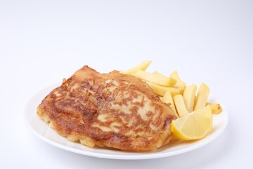 Tasty fish in soda water batter, potato chips and lemon slice isolated on white