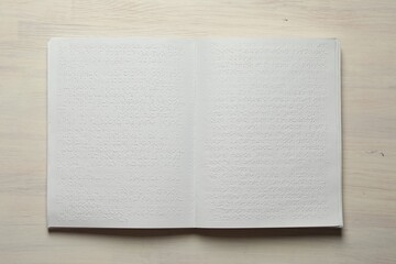 Book with Braille text on wooden table, top view. Education and leisure for blind people