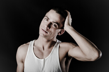 Young attractive man with athletic body posing in studio.