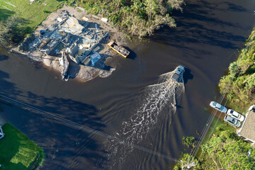 Aerial view of flooded street after hurricane rainfall with driving cars in Florida residential area. Consequences of natural disaster
