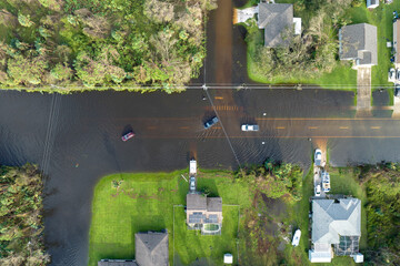Aerial view of flooded street after hurricane rainfall with driving cars in Florida residential...