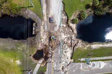 Construction equipment at roadworks site. Reconstruction of damaged road bridge destroyed by river...